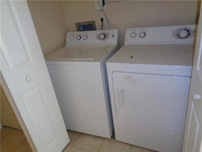 A white washing machine and dryer in a small laundry room.