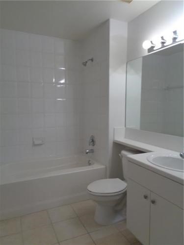 A white toilet sits next to a bathtub in a bathroom.