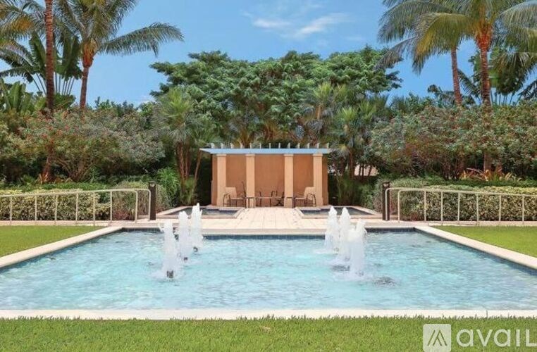 A pool with a fountain in the middle of it.