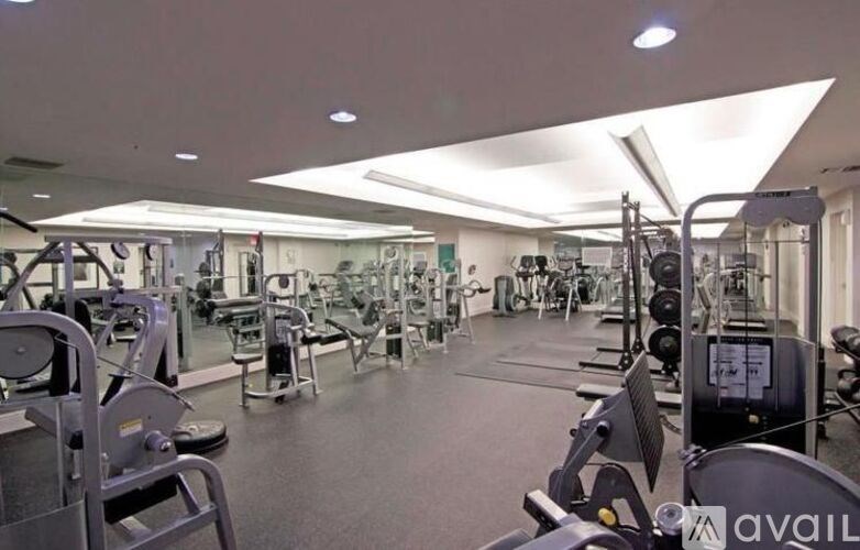 A gym with a variety of equipment including treadmills, weights, and exercise machines.
