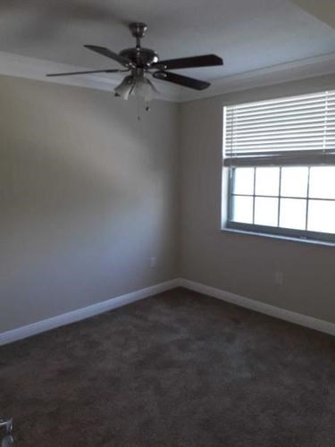 A room with a ceiling fan and a window.