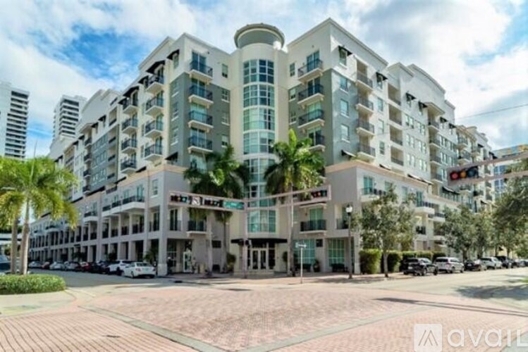 A large white building with a curved corner and a balcony on the top floor.