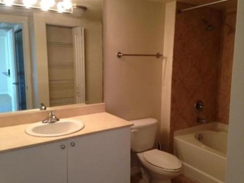 A bathroom with a sink, toilet, and bathtub.