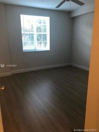 A room with a wooden floor and a window letting in light.