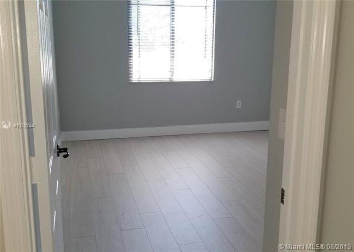 A room with a white tile floor and a window with blinds.