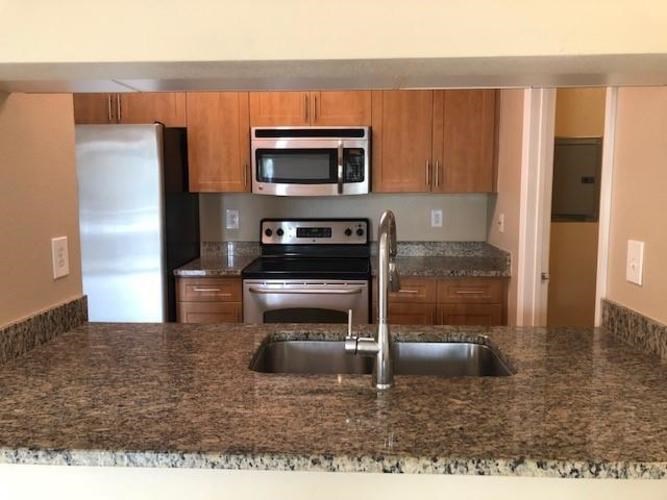 A kitchen with granite countertops and stainless steel appliances.