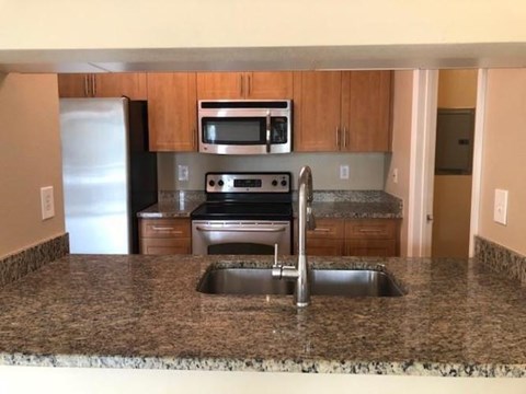 A kitchen with granite countertops and stainless steel appliances.