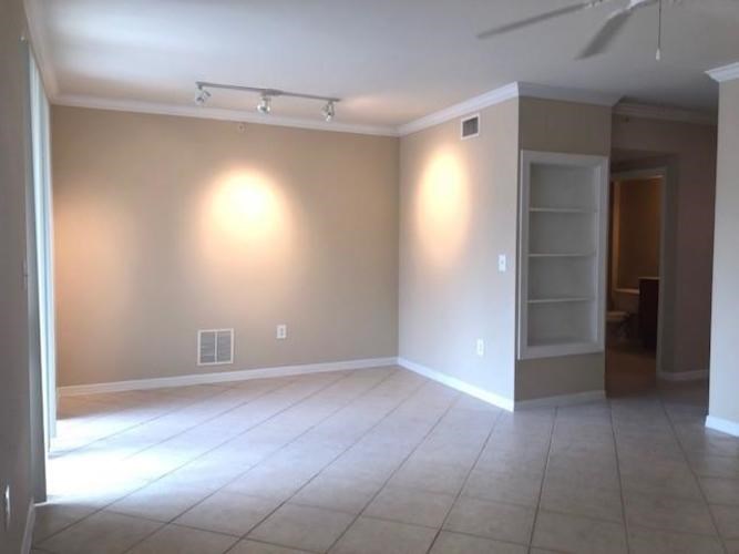 A room with a ceiling fan and a light switch.