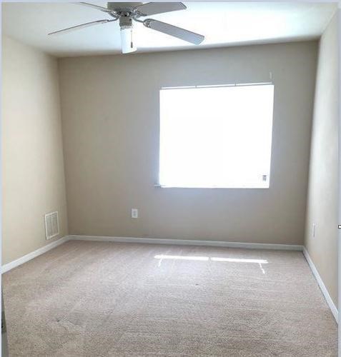 A room with a ceiling fan and a window.