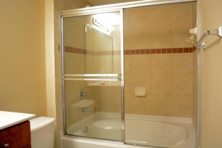 A bathroom with a glass shower door and a white toilet.