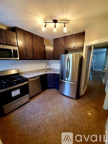 A kitchen with brown cabinets and a refrigerator.