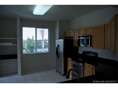 A kitchen with black appliances and wooden cabinets.