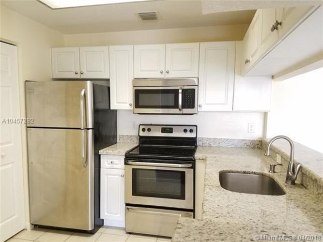 A kitchen with a stainless steel refrigerator, microwave, oven, and sink.