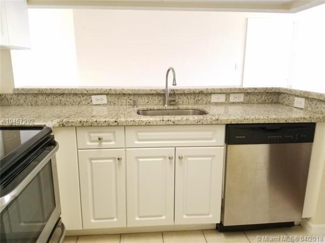 A kitchen with a sink, dishwasher and microwave.