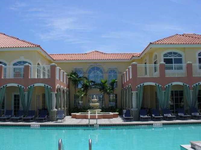 A large building with a pool in front of it.