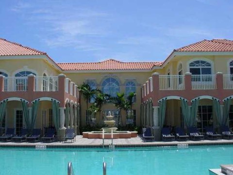 A large building with a pool in front of it.