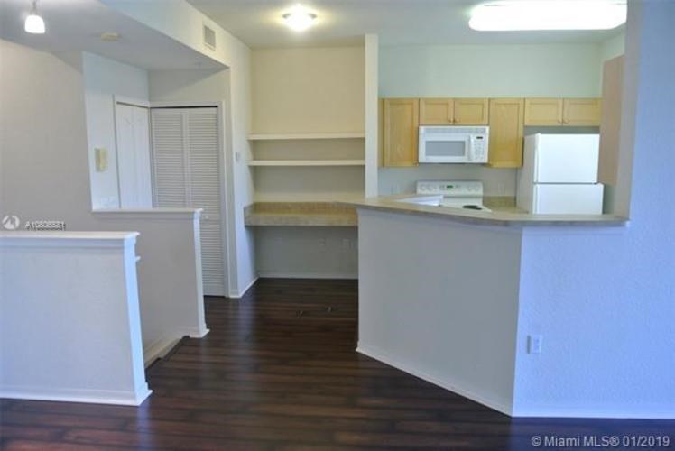 A kitchen with white cabinets and a microwave.