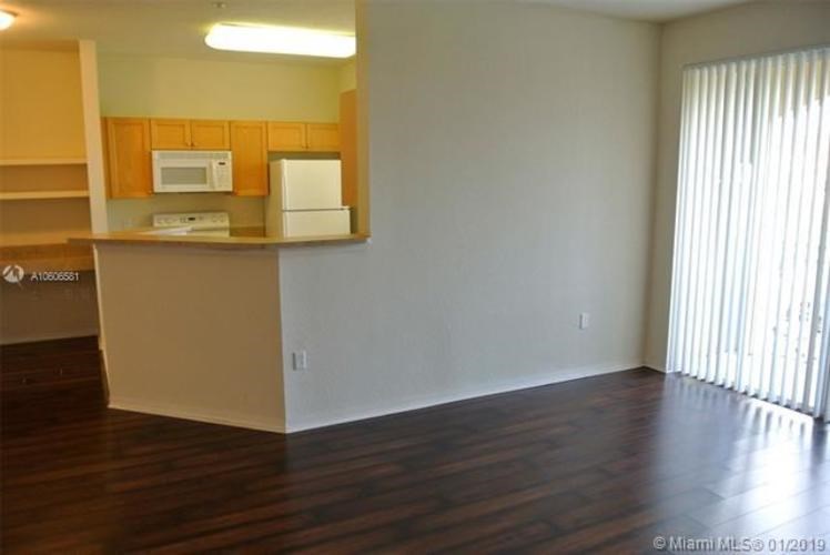 A kitchen with white appliances and wooden cabinets.