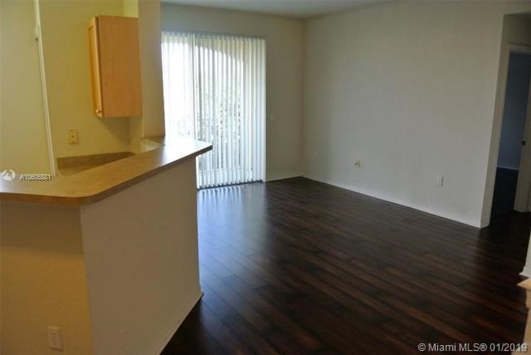 A kitchen area with a counter and a window with blinds.