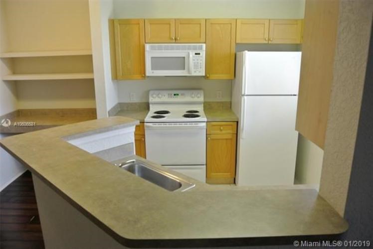 A kitchen with a stove, microwave, and refrigerator.