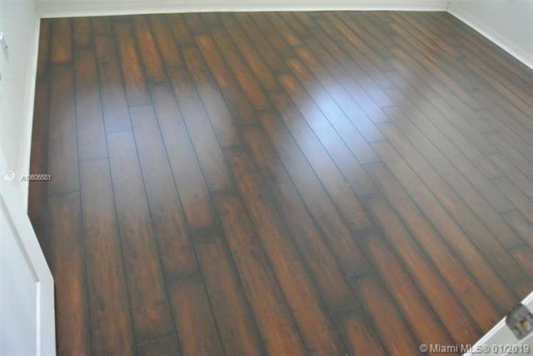 A wooden floor in a room with white walls.