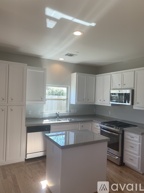 A kitchen with white cabinets and a black countertop.