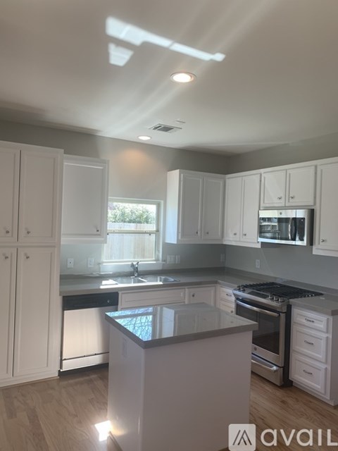 A kitchen with white cabinets and a black countertop.
