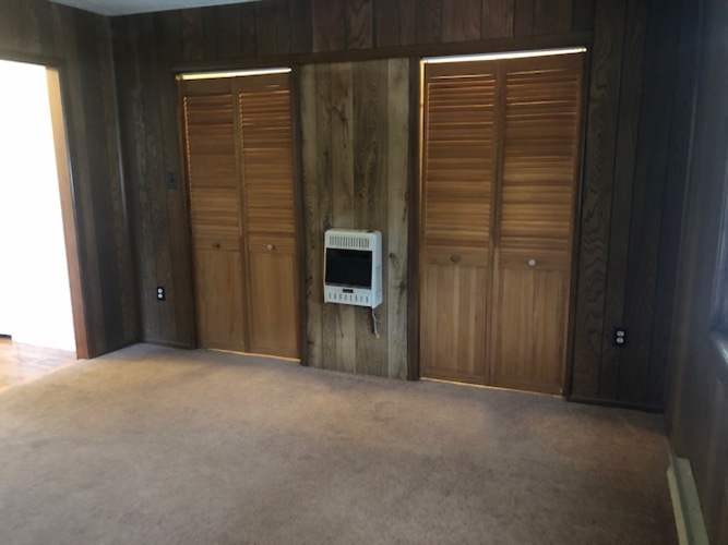 A room with a wooden wall and a white box on it.