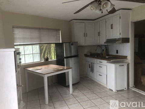 A kitchen with white cabinets and a table with two plates on it.