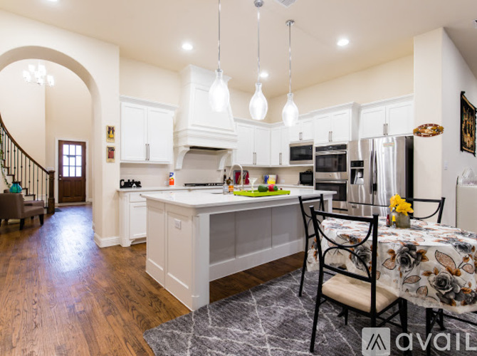 A kitchen with a table set for two and a dining area.