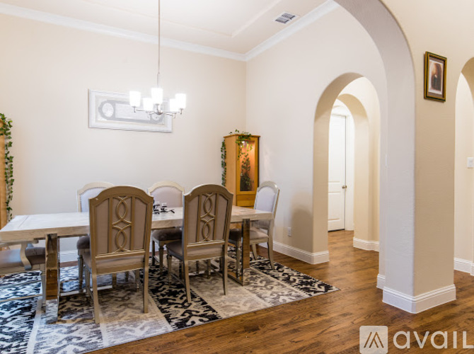A dining room with a white table and chairs.