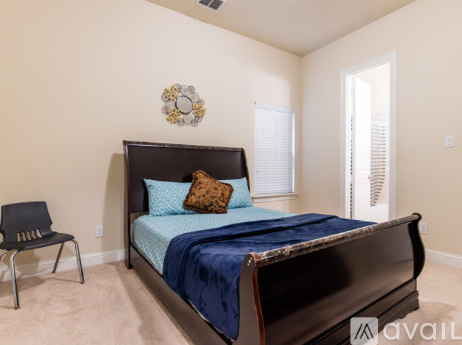 A bedroom with a dark wooden bed and a blue bedspread.