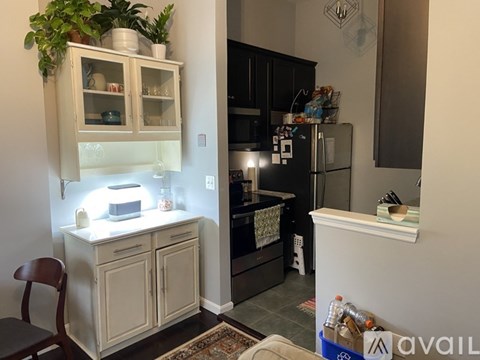 A kitchen with a white cabinet and a black fridge.
