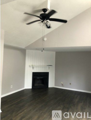 A room with a fan and a fireplace.