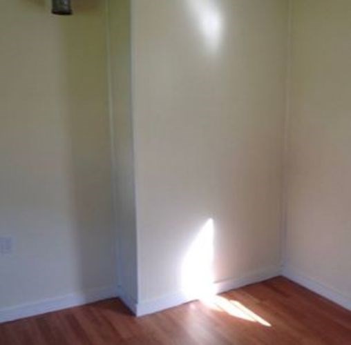 A room with a wooden floor and white walls.