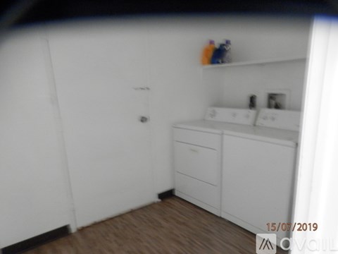 A white bathroom with a wooden floor and a white cabinet.
