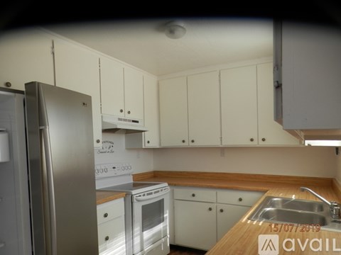 A kitchen with white cabinets and a wooden countertop.