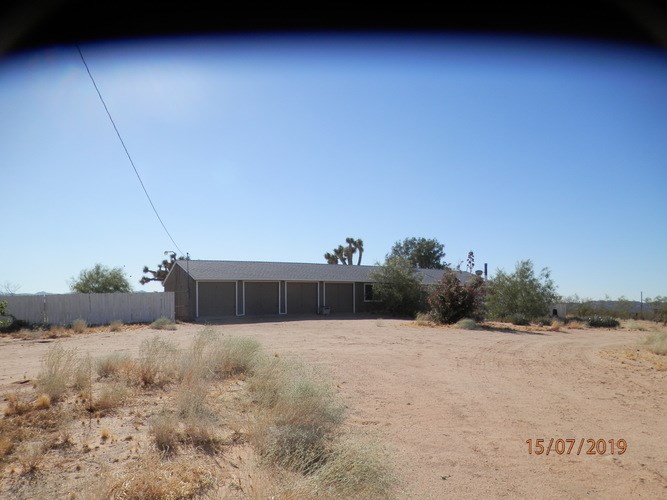 A house in a desert with a date stamp of 15/07/2019.
