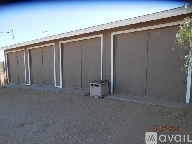 A row of garage doors are closed and a white box is in front of the first one.