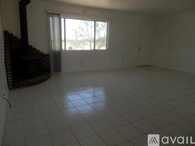 A room with a brick fireplace and a large window.