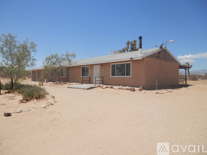 A house in a desert with a clear blue sky.
