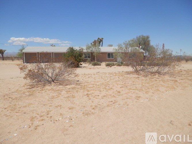 A house in a desert with a clear blue sky.