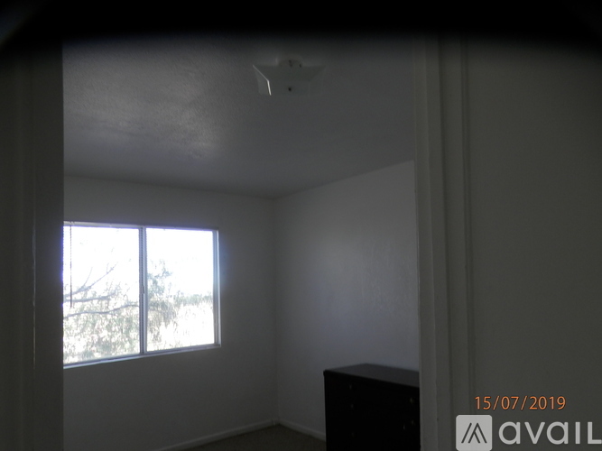 A room with a window and a ceiling fan.