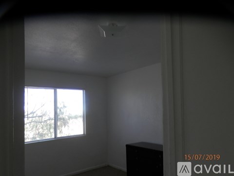 A room with a window and a ceiling fan.