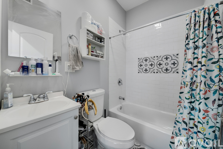 A bathroom with a white toilet, sink, and shower curtain.