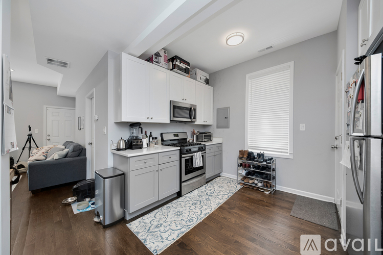 A kitchen with white cabinets and a patterned rug on the floor.