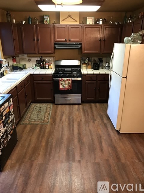 A kitchen with brown cabinets and a white fridge.