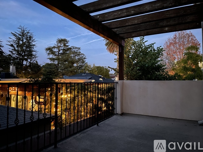 A balcony with a railing and lights under a wooden roof.