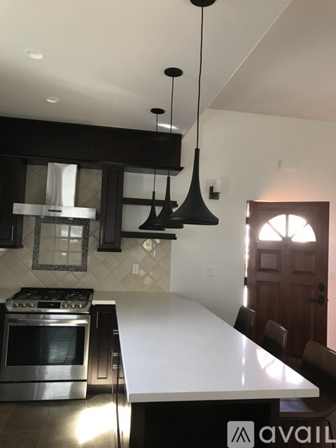 A kitchen with a white counter top and black cabinets.