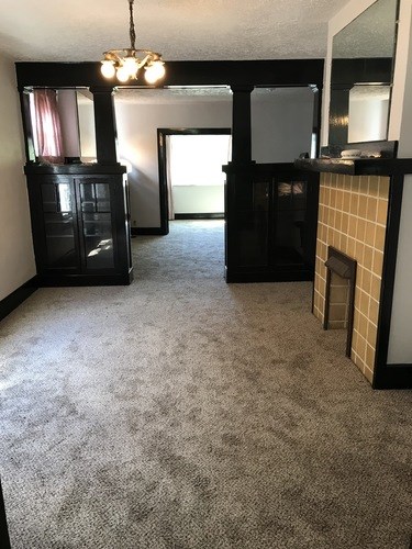 A living room with a fireplace and a chandelier.